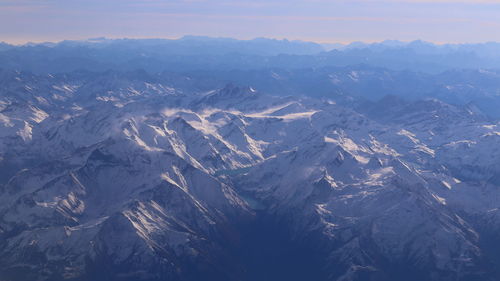 Aerial view of snowcapped mountains against sky