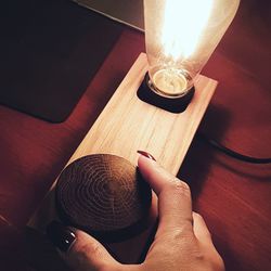 High angle view of hand holding candle on table