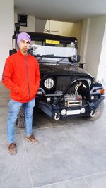 Portrait of man standing in car