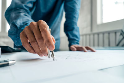 Midsection of man working on table