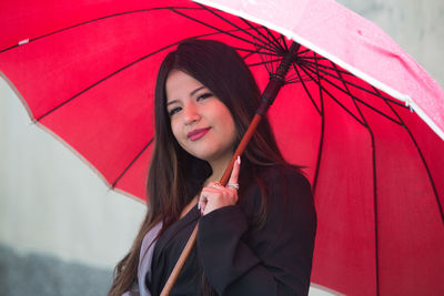Portrait of beautiful young woman standing in rain