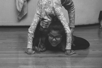 High angle view of baby girl sitting on hardwood floor at home