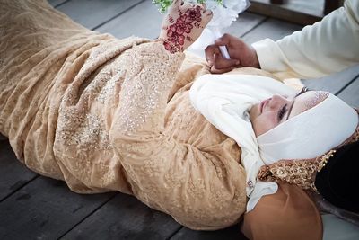 Rear view of woman lying down on floor