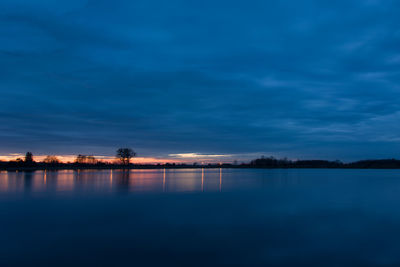 Scenic view of lake against sky at sunset