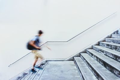 Blurred motion of man moving up staircase