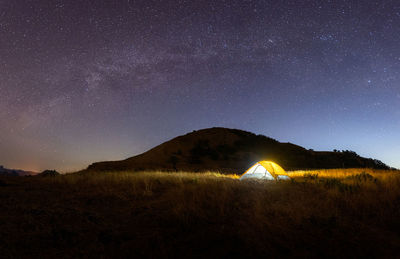 Scenic view of illuminated field against sky at night