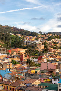 Houses in town against cloudy sky