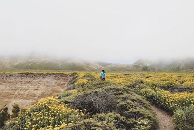 Rear view of man on mountain against sky