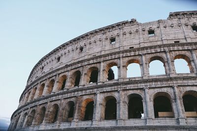 Low angle view of coliseum against clear sky