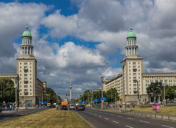 Buildings in city against cloudy sky