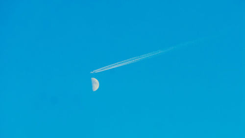 Low angle view of vapor trail against clear blue sky