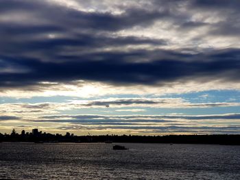 Scenic view of dramatic sky over river during sunset