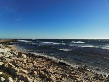 Scenic view of sea against clear blue sky