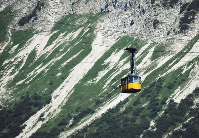 Low angle view of overhead cable car against mountain