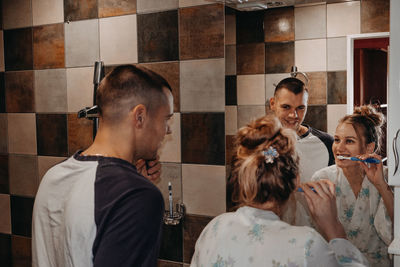 Young man with arms raised in bathroom