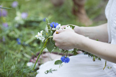 Midsection of woman picking flowers