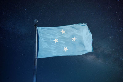 Low angle view of micronesian flag against star field sky