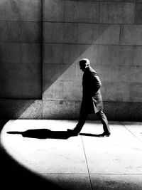 Full length of man walking on sidewalk