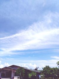 Low angle view of trees and buildings against sky