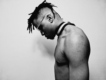 Portrait of young man looking away against white background