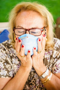 Close-up of senior woman with eyes closed wearing mask