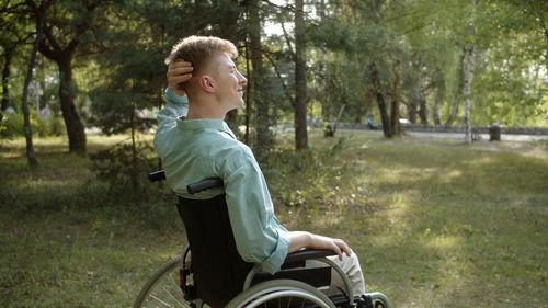 Side view of boy riding bicycle on field