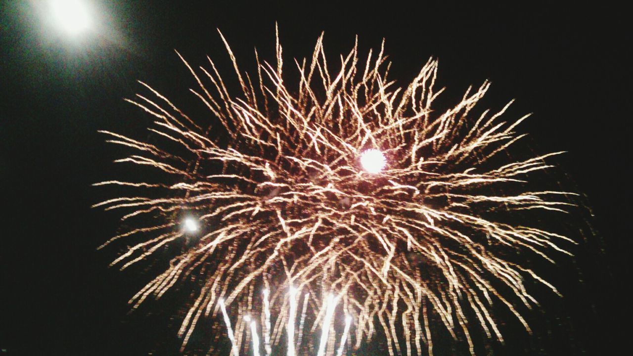 night, celebration, firework display, exploding, low angle view, glowing, illuminated, firework - man made object, long exposure, firework, sparks, event, motion, sky, arts culture and entertainment, entertainment, celebration event, fire - natural phenomenon, clear sky, outdoors