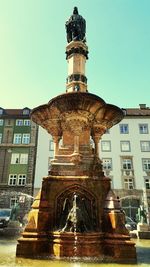 Low angle view of statue against buildings in city