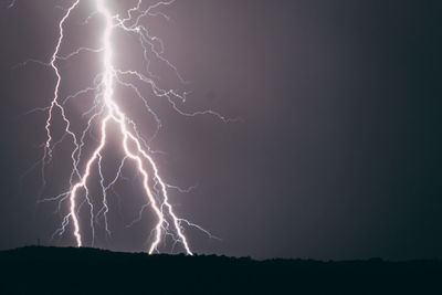 Low angle view of lightning against sky at night