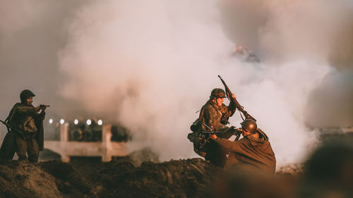 People standing on fire against sky