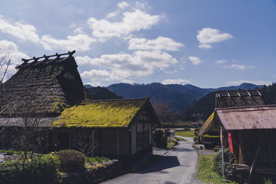 Houses amidst plants and buildings against sky