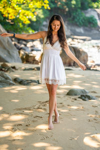 Portrait of young woman standing at beach