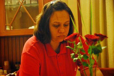 Woman in red holding red rose