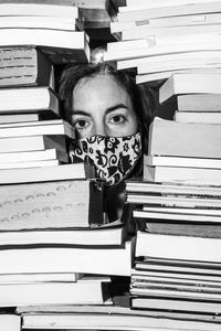 Portrait of young woman with books on table