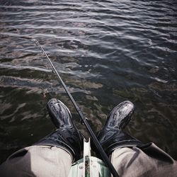 Low section of person standing in water