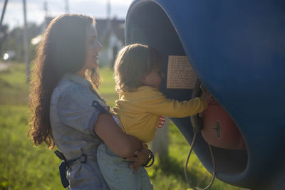 Side view of mother and daughter outdoors