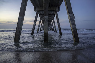 Pier on sea against sky at sunset