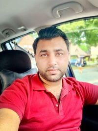 Portrait of young man sitting in car