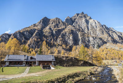 Scenic view of house and mountains against sky