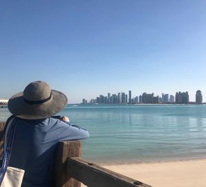 Rear view of woman looking at sea against clear sky