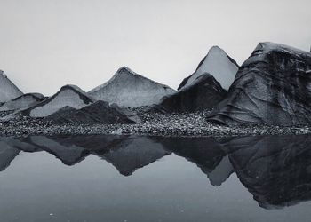 Reflection of mountain in lake against clear sky