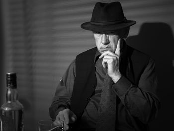 Portrait of man drinking alcohol while sitting at table