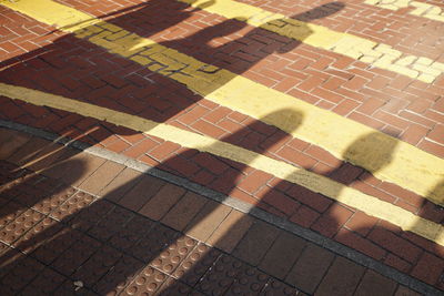 High angle view of shadow on tiled floor