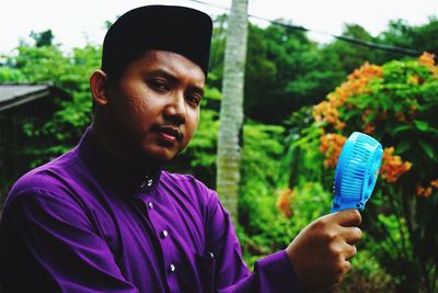 Portrait of young man holding purple outdoors