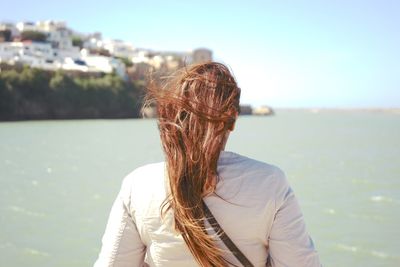 Rear view of woman standing against sea