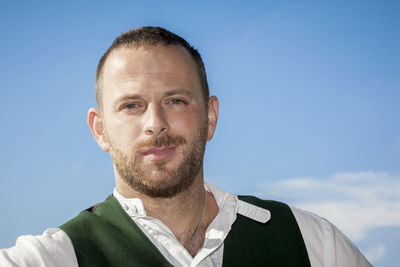 Close-up portrait of man in traditional clothing against sky