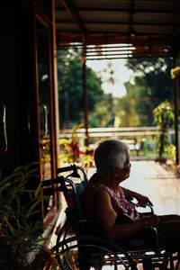 Rear view of man sitting by window