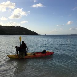 Man rowing boat on lake against sky