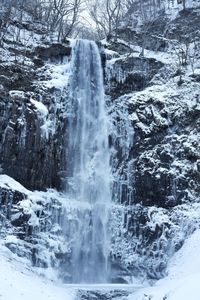 Scenic view of waterfall in forest during winter