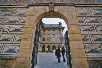 Rear view of people walking on historical building